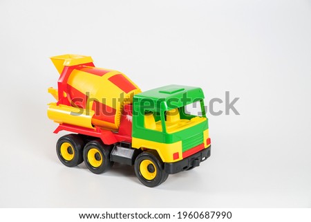 Multi-colored plastic children's toy cars on a white background. Concrete truck.