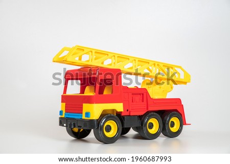 Children's toy plastic car isolated on white background. Red fire truck.