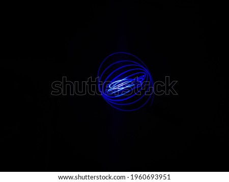 Closeup of Neon blue Spirograph geometric pattern abstract flowing in a isolated Black background. Pendullum Motion.