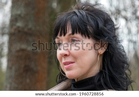 Portrait of pretty smiling middle aged 45 years old woman with long dark hair smiling