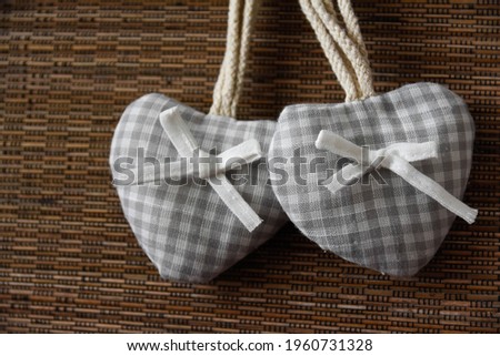 Light colored fabric hearts on a brown wood type background
