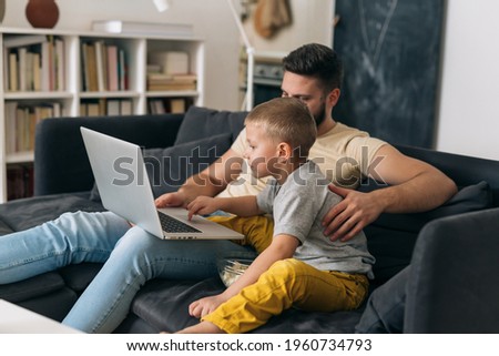 father and son using computer at home