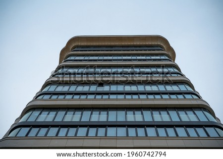 Bottom up view of the facade of a building made of white natural stone with panoramic windows. Modern architecture of Moscow. Detailed pictures of exterior urban architecture.