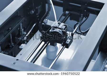 Objects printed by 3d printer. Automatic three dimensional 3d printer performs Royalty-Free Stock Photo #1960750522