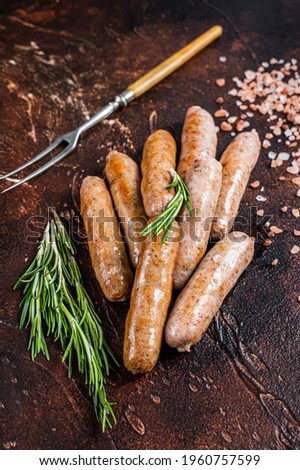 Grilled pork and beef meat sausages on a kitchen table. Dark background. Top View