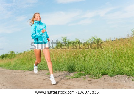 young woman running along a rural road, exercise outdoors