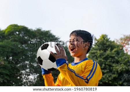 Portrait Of A boy shouting holding Soccer Ball Royalty-Free Stock Photo #1960780819