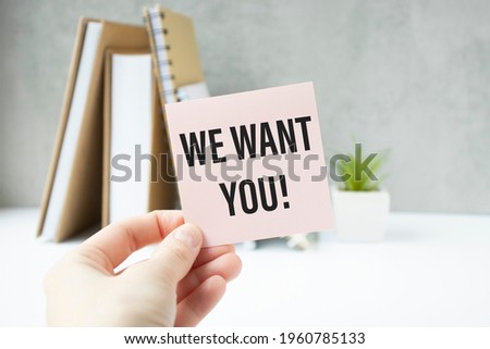WE WANT YOU message on the card shown by a woman