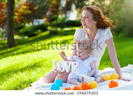 Beautiful Mother And Baby outdoors. Happy mum and her Child playing in Park together. Outdoor Portrait of happy family
