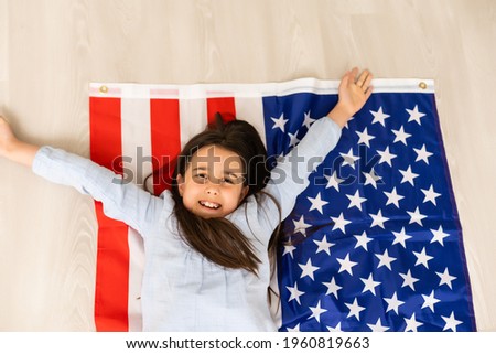 Portrait of a little girl with the flag of America. American education, study in America