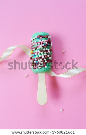 Mint-colored ice cream with multicolored sprinkles lies on a pink background.The decor is a ribbon.
Concept-store of sweets, candies.
