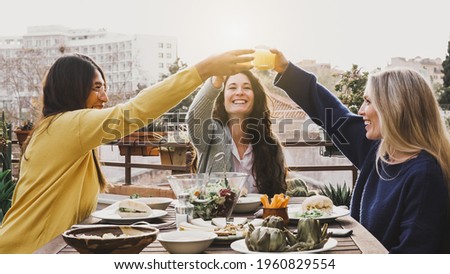 Young multiracial people eating and cheering with juice - Soft focus on right woman face