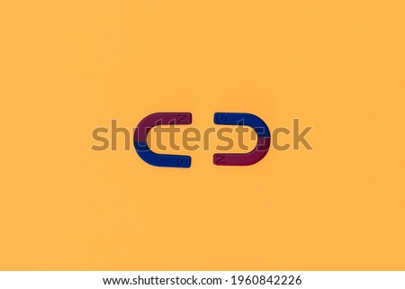 blue and red horseshoe magnet marking the positive and negative poles on a yellow-orange background