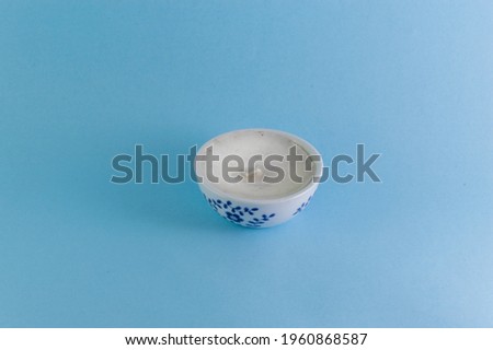 A small scented candle isolated on blue background 