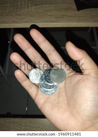 Picture of coins in the palm of hand.