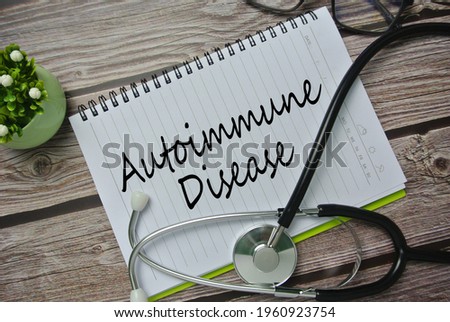 Selective focus of stethoscope, flower, spectacle and notebook written with AUTOIMMUNE DISEASE. It is a condition in which your immune system mistakenly attacks your body Royalty-Free Stock Photo #1960923754