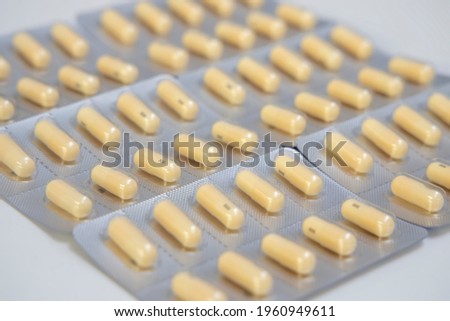 Selective focus at capsule with blur background.Herb capsule, Nutritional Supplement, Vitamin Pill, Herbal Medicine capsules in blister package.Pharmaceutical industry concept. Pharmacy drugstore. 