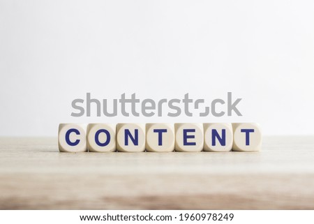 A word "content" on a wooden table over the light background.