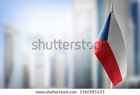 A small flag of Czechia on the background of a blurred background