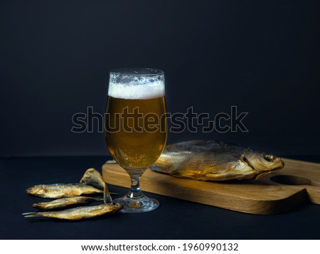 dried salted roach and bream, delicious clip fish on a wooden background with a glass of fresh beer. A popular beer snack. advertising of beer restaurants. Close-up, copy space. selective focus.banner