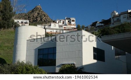 Detail of modern building wall with large window and round corner tower in Andalusian Village
