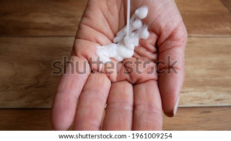 The cream falls into a woman's hand. Aging skin care Royalty-Free Stock Photo #1961009254