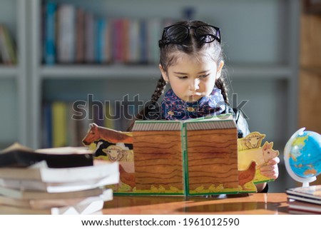 little foreigner girl learning with intention and happy.