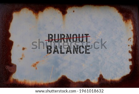 Rusty plate with text from BURNOUT (red crossing line) to BALANCE , concept of burnout ( chronic stress at work, negative attitude and poor performance) need to be reversed with work life balance