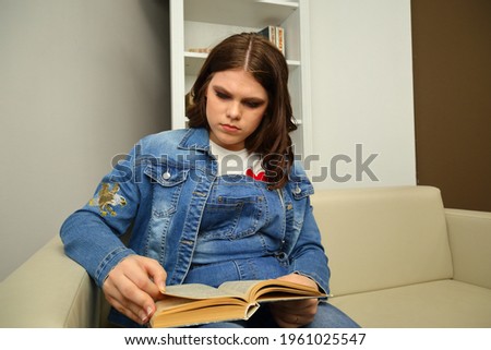 A young girl sitting in a chair. High quality photo