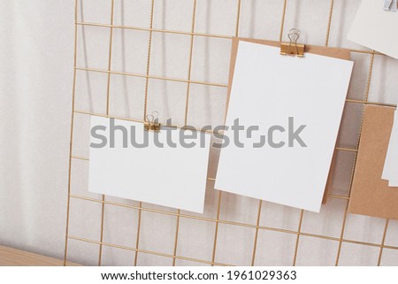 Poster, cards mock up attached on gold grid board with binder. Natural beige colors interior part, mood board template. White blank paper for prints, photography, to do or planning lists.