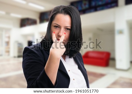 Corporate businesswoman wearing office suit with serious expression making eye contact gesture pointing as supervisor concept Royalty-Free Stock Photo #1961051770