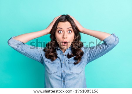 Photo of young attractive girl hands touch head amazed shocked fake novelty news isolated over turquoise color background