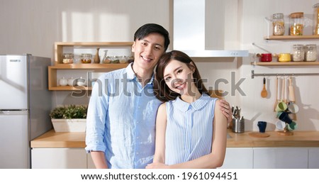 asian couple smile to you in the kitchen at home