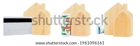 Miniature wooden houses with money bills and a bank credit card isolated on a white background. The concept of buying a house, the symbol of a loan for a house, the price of a house.