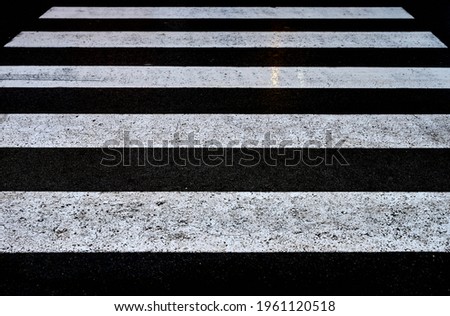 detail of a view of a black and white crosswalk in the rain