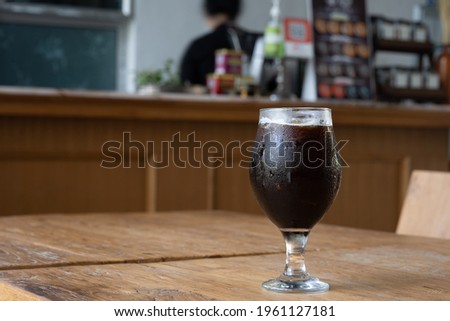 A glass of cold black beer on a wooden floor