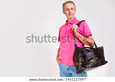 Modern Lifestyle Concepts. Portarit of Positive Tranquil Caucasian Handsome Man Posing With Leather Travel Bag On White. Horizontal Image