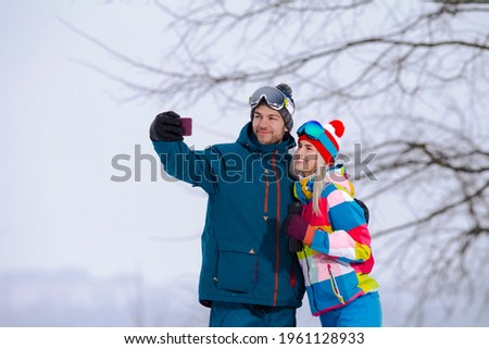 Smiling  Caucasian Couple Taking Selfie Pictures During Tube Activities In Winter Time in Mountains. Horizontal Image