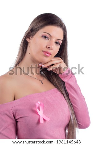 Beautiful young woman with pink dress on a white background with a pink awareness ribbon for breast cancer.