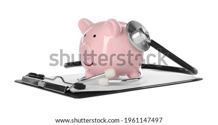 Piggy bank, stethoscope and clipboard on white background