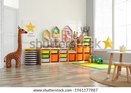 Stylish playroom interior with shelving unit and different soft toys Royalty-Free Stock Photo #1961177887