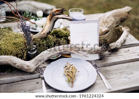 White business card stands on a beautifully served rustic table with flowers and bouquets