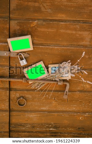 Blank portraits and a bouquet of wildflowers on the background of a beautiful wooden door with a bolt