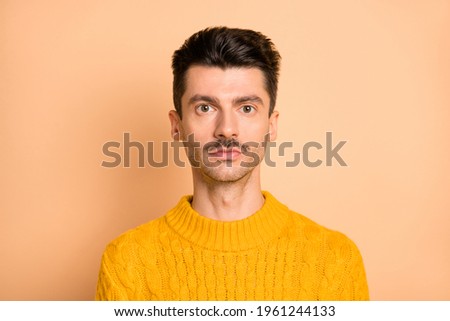 Photo portrait of serious man with mustache wearing bright yellow sweater isolated on pastel beige color background