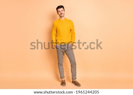 Photo portrait full body view of confident man with hands in pockets isolated on pastel beige colored background