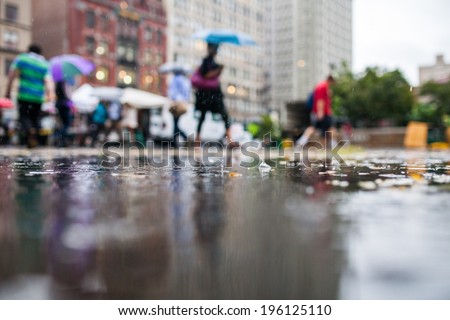 Rainy Day in the City with People Holding Umbrellas in the Background