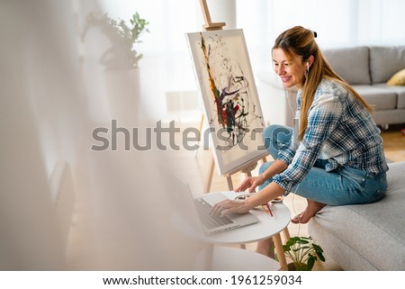 Creative beautiful woman painting at home. Coronavirus quarantine, isolation.