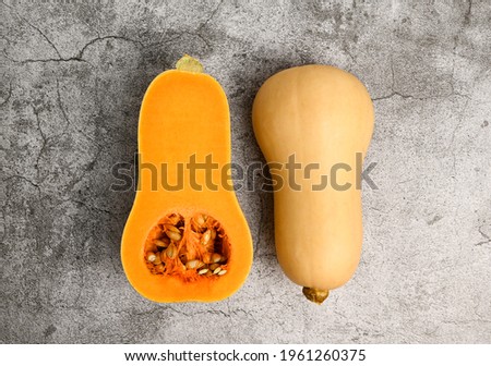 Cut in half Butternut squash against concrete background. Healthy food.Print for stand for plates. Kitchen picture