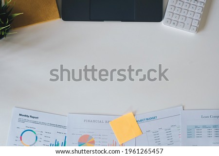 Accounting concept with laptop computer, calculator and financial documents on workplace with copyspace. Above view