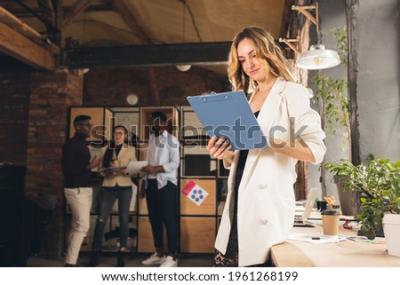 Lifestyle. Manager, woman with folder researching, reading documents, look attented and composed. Discussing, making decisions, routine tasks, projects. Successful corporate teamwork.